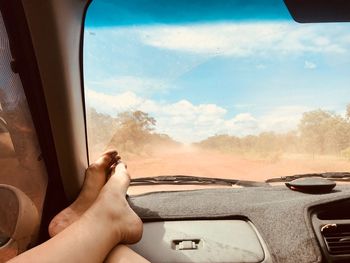 Low section of woman relaxing in car