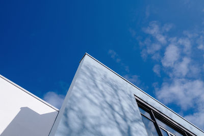 Low angle view of modern building against blue sky