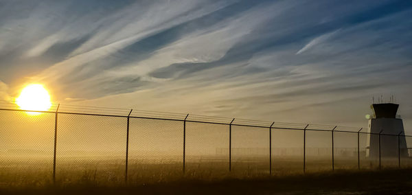 Fence against sky during sunset