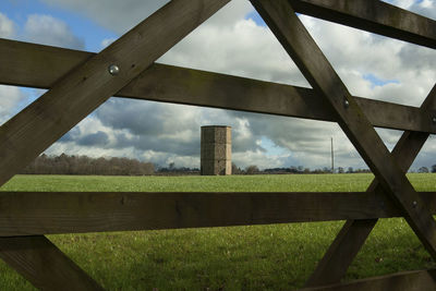 View of field against cloudy sky