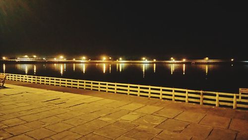 Illuminated bridge against sky at night