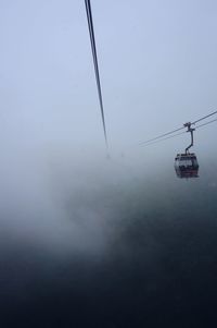 Low angle view of overhead cable car against sky