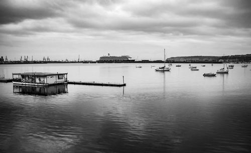 Boats in harbor against sky