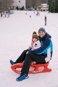 Full length of boy sitting on snow