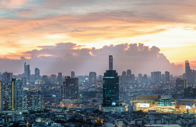 Modern buildings against sky during sunset