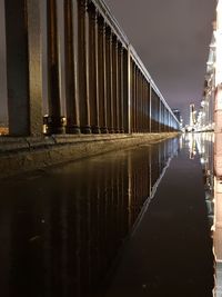 Bridge over river against sky in city at night