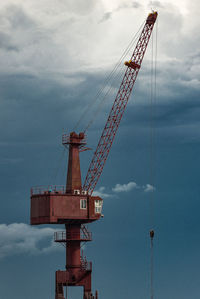 Low angle view of crane against sky