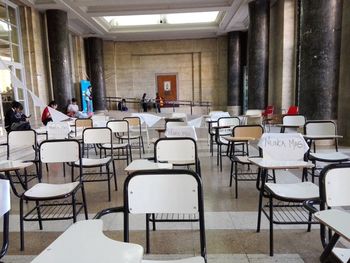 Empty chairs and tables in building