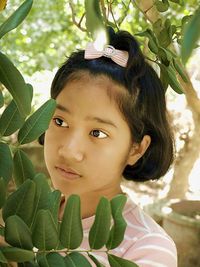 Close-up of girl looking at plant
