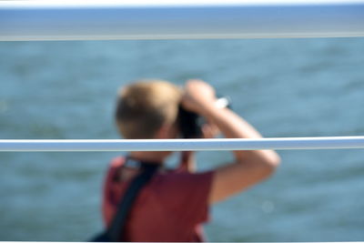 Rear view of woman photographing sea