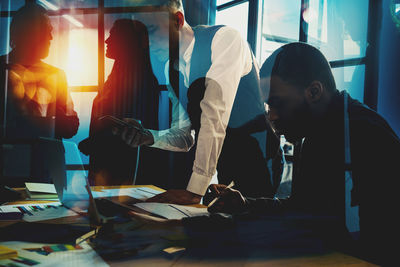 Rear view of people working at office