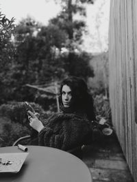 Portrait of young woman sitting outdoors