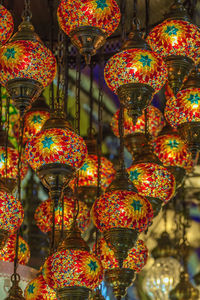Illuminated lanterns hanging in market stall for sale