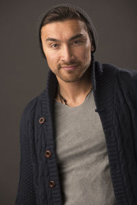 Portrait of male model standing against brown background