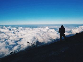 Silhouette man walking on landscape against sky