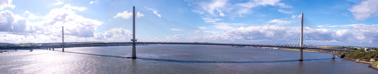 Panoramic view of bridge over sea against cloudy sky