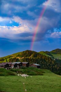 Scenic view of rainbow over river against sky