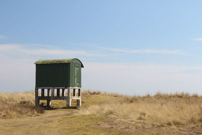 Built structure on field against sky
