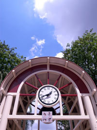 Low angle view of clock on tree against sky