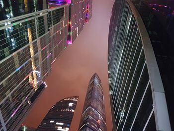 Low angle view of illuminated buildings against sky at night