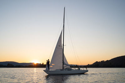 Sailboat sailing on sea during sunset
