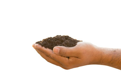 Close-up of hand holding ice cream over white background