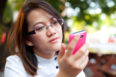 Close-up of woman using mobile phone outdoors