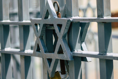 Close-up of metal fence against railing