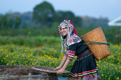 Woman holding umbrella in field