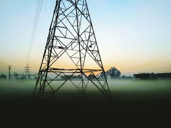 Silhouette electricity pylon against sky during sunset