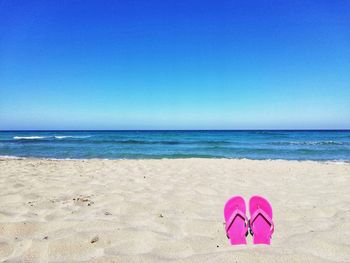 Scenic view of beach against clear blue sky