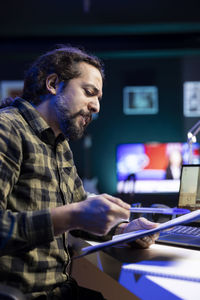 Side view of young man working at office