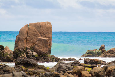 Scenic view of rocks on beach against sky