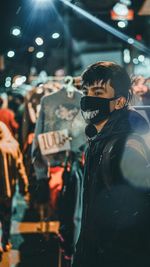 Man wearing mask and looking away while standing in store