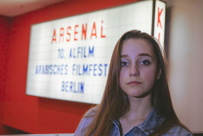 Portrait of woman against illuminated banner with text