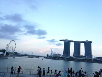 People at observation point against sky in city