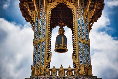 Thai traditional bell tower with detailed, mosaic artwork and gold colored design
