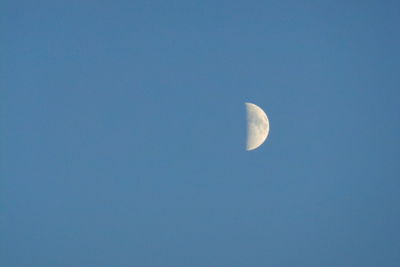 Low angle view of moon against blue sky