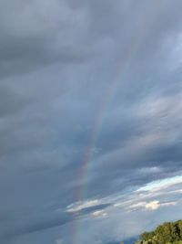 Low angle view of rainbow against cloudy sky