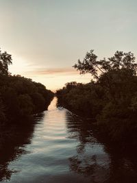 Scenic view of river against sky at sunset