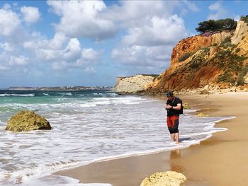 People on beach by sea against sky
