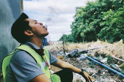 Side view of young man smoking cigarette