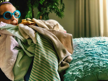 Close-up of woman wearing eyeglasses while holding laundry at home