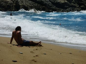 Full length of shirtless man on beach