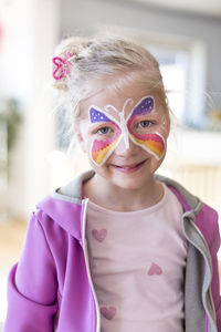 Portrait of smiling girl with painted butterfly on face