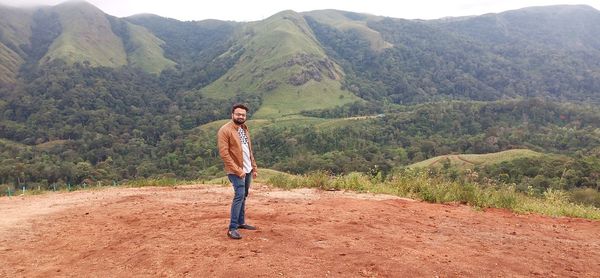 Full length of young man standing on mountain