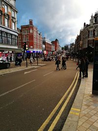 People on street in city against sky