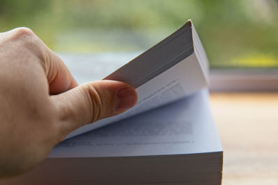 Close-up of hand holding book