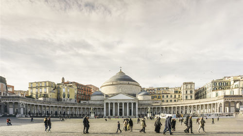 Group of people in front of historic building against sky