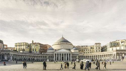 Group of people in front of historic building against sky . piazza del plebiscito napoli